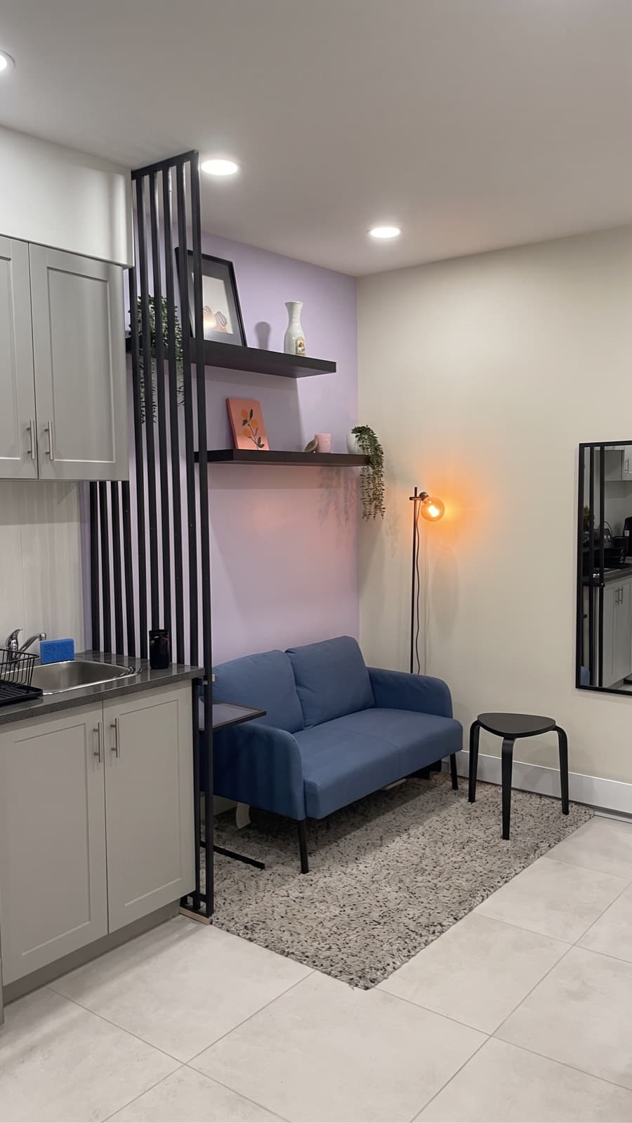 Coin salon résidentiel avec mur d'accent mauve derrière un sofa bleu, peint par Peinture Maestro